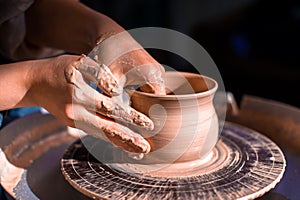 Ceramist master works with clay on a potter`s wheel. Artisan production. Close-up.