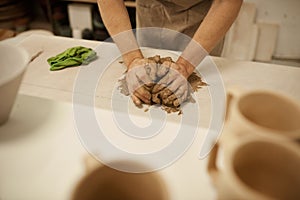Ceramist working with a piece of clay on a studio table photo