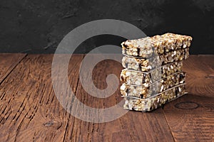 Cereal bars with nuts, berries and cinnamon on a wooden background. Copy space. Food background