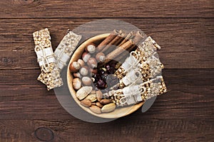 Cereal bars with nuts, berries and cinnamon on a wooden background. Top view. Food background