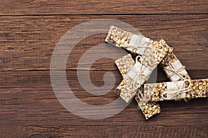 Cereal bars with nuts, berries and cinnamon on a wooden background. Top view, copy space. Food background