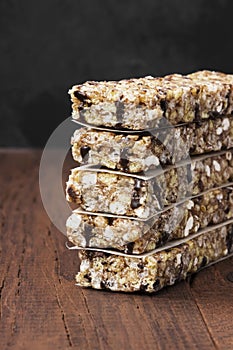 Cereal bars with nuts, berries and cinnamon on a wooden background