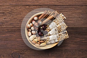 Cereal bars with nuts, berries and cinnamon on a wooden background. Top view. Food background