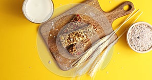 Cereal bars and oats on wooden board