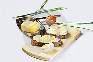 Cereal bread,boiled egg, butter,chive, wooden board.