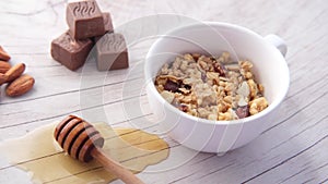 cereal breakfast in bowl , nut , chocolate and honey on table
