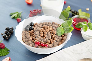 Cereal chocolate balls in bowl with milk on rustic wooden table Healthy tasty breakfast chocolate balls with