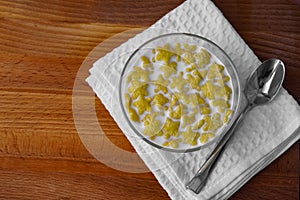 Cereal with milk on a white napkin on a wooden table