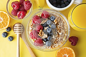 Cereal, muesli and various delicious fruit, berries for breakfast. healthy, energy breakfast, yellow colorful background