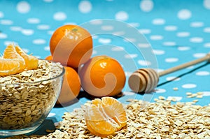 Cereal on the table, tangerines and spoon for honey