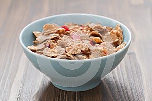 Cereals in blue bowl on brown background