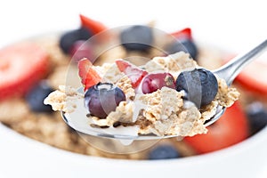 Cereals bowl with red fruits on white