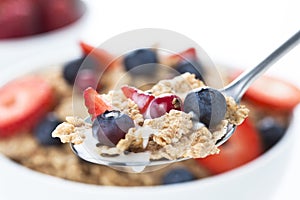 Cereals bowl with red fruits on white