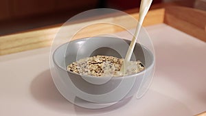Cereals milk poured in a bowl in slow motion