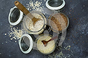 Cereals oatmeal, buckwheat, rice in glass jars in the kitchen. Gluten free concept. Varieties of cereals for making healthy