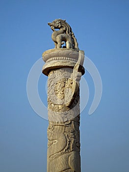 A ceremonial stone column with a dragon on top at the entrance to Forbidden City, Beijing