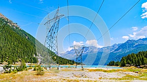 Ceresole Reale, Italy. High voltage pylons close to Lake Ceresole, in Piedmont. Pollution concept, energy supply, infrastructure,