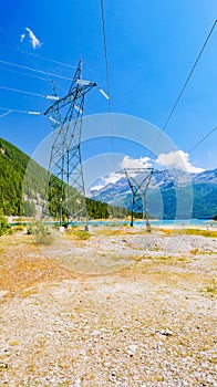 Ceresole Reale, Italy. High voltage pylons close to Lake Ceresole, in Piedmont. Pollution concept, energy supply, infrastructure,