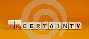 Certainty or Uncertainty symbol. Turned wooden cubes and changed concept words Uncertainty to Certainty. Beautiful orange