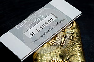 The certificate of assay for gold bars lies on a cast gold ingot.