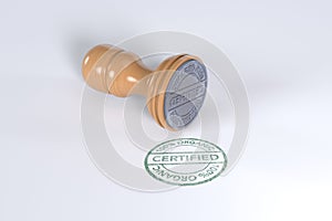 100% Certified organic text stamp with wooden rubber stamper Green color superior quality isolated on white background.