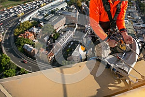 Certifies rope access high rise worker licences using yellow ascender descending with low stretch abseiling rope over the edge photo