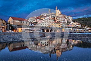 Cervo town reflecting in water at dusk, Liguria, Italy