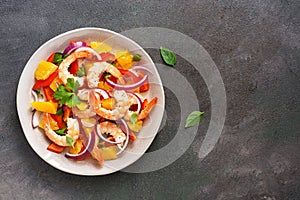 Ceviche salad with shrimps and oranges on a dark rustic background. Latin American food. Top view, flat lay, copy space