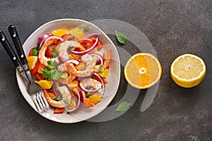 Ceviche salad with shrimps and oranges on a dark rustic background. Latin American food. Top view, flat lay, copy space