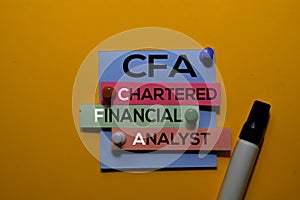 CFA. Chartered Financial Analyst acronym on sticky notes. Office desk background