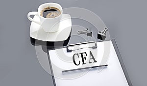 CFA text on paper sheet with coffee on the black background