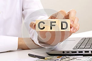 CFD - acronym from wooden blocks with letters, Contract For Difference. CFD investment concept