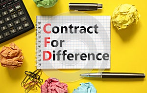 CFD symbol. Concept words CFD contract of difference on beautiful white note. Beautiful yellow table yellow background. Calculator