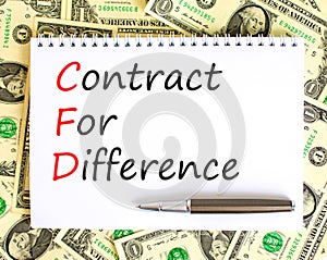 CFD symbol. Concept words CFD contract of difference on beautiful white note. Dollar bills. Beautiful background from dollar bills