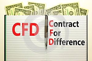 CFD symbol. Concept words CFD contract of difference on beautiful white note. Dollar bills. Beautiful white table white background