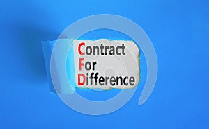 CFD symbol. Concept words CFD contract of difference on beautiful white paper. Beautiful blue table blue background. Business and