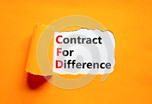 CFD symbol. Concept words CFD contract of difference on beautiful white paper. Beautiful orange table orange background. Business