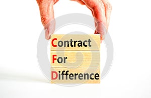 CFD symbol. Concept words CFD contract of difference on beautiful wooden block. Businessman hand. Beautiful white table white