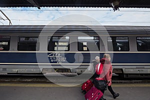 CFR Calatori logo on intercity train in Gara de Nord, main railway station of Bucharest with passengers passing by