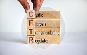 CFTR medical concept. Wooden cubes and blocks with the inscription `CFTR - cystic fibrosis transmembrane regulator`, male hand.