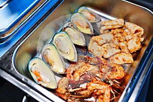 Chafing Dish with assorted grilled mussels and shrimps