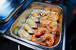 Chafing Dish with assorted grilled mussels and shrimps