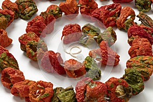 Chain of dried peppers, Biber Kurusu, on white background photo