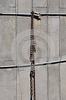 Chain hangs from a metal rod of an old stave silo