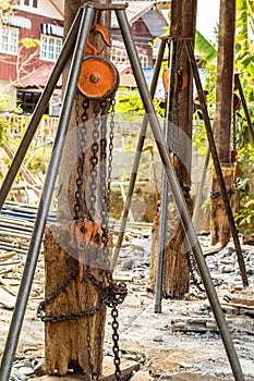 Chain hoist with a large wooden pole.