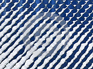 chain link fence covered with fresh white snow on blue background