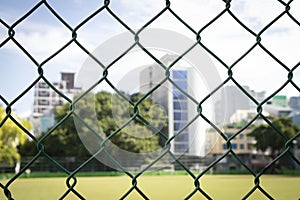 Chain Link Fencing background with blurred buildings back