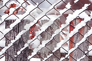 Chain-link fencing covered by snow.