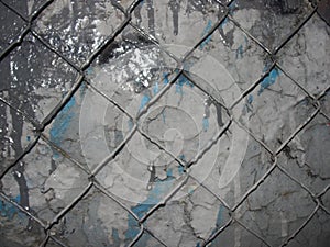 Chain link mesh on a gray painted background - vandal-proof protection of municipal and departmental property. no graffiti