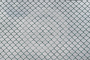 Chain link metal fence with white background.